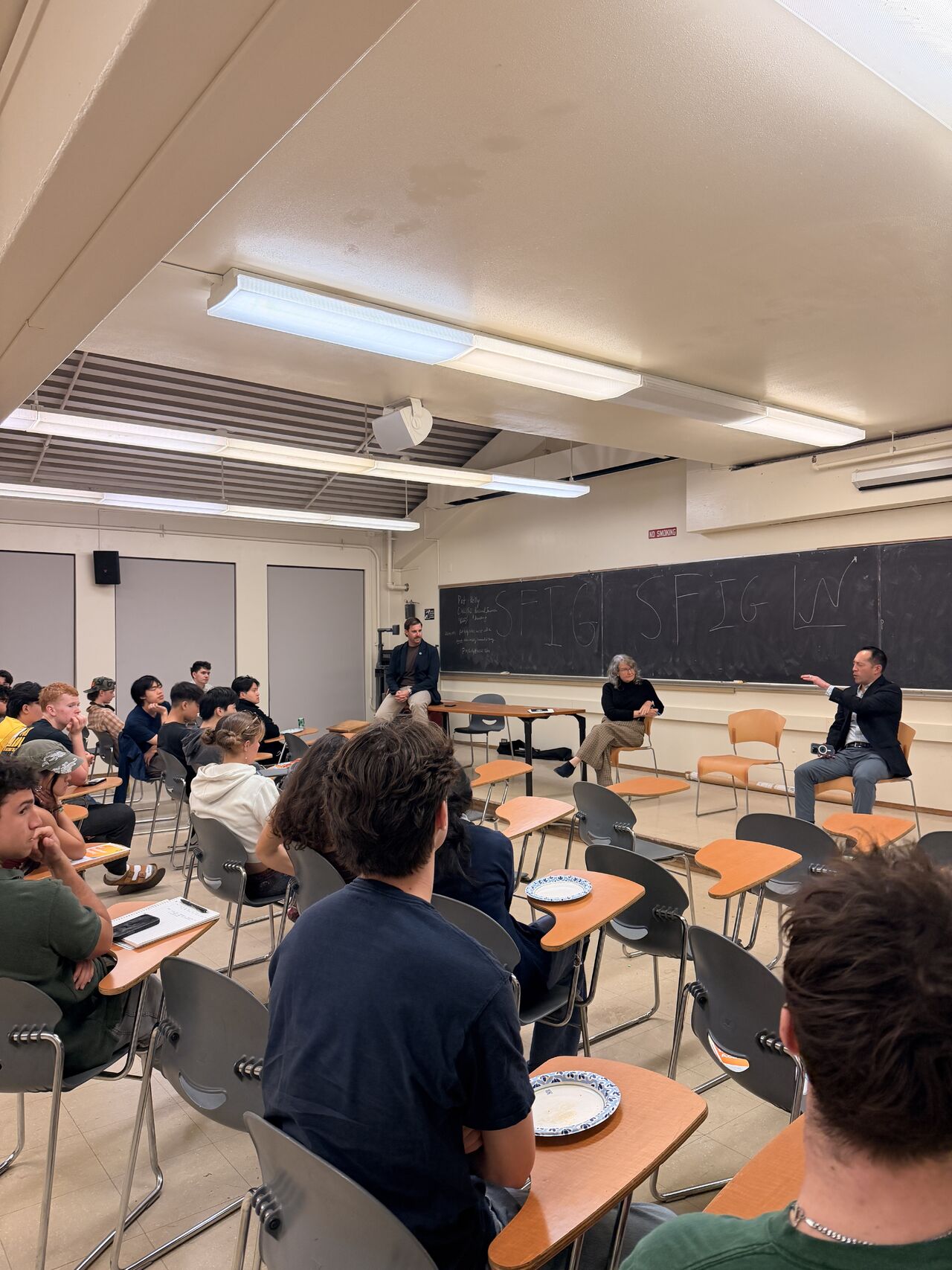 Three UC Investments guests seated at the front of a classroom taking questions from students