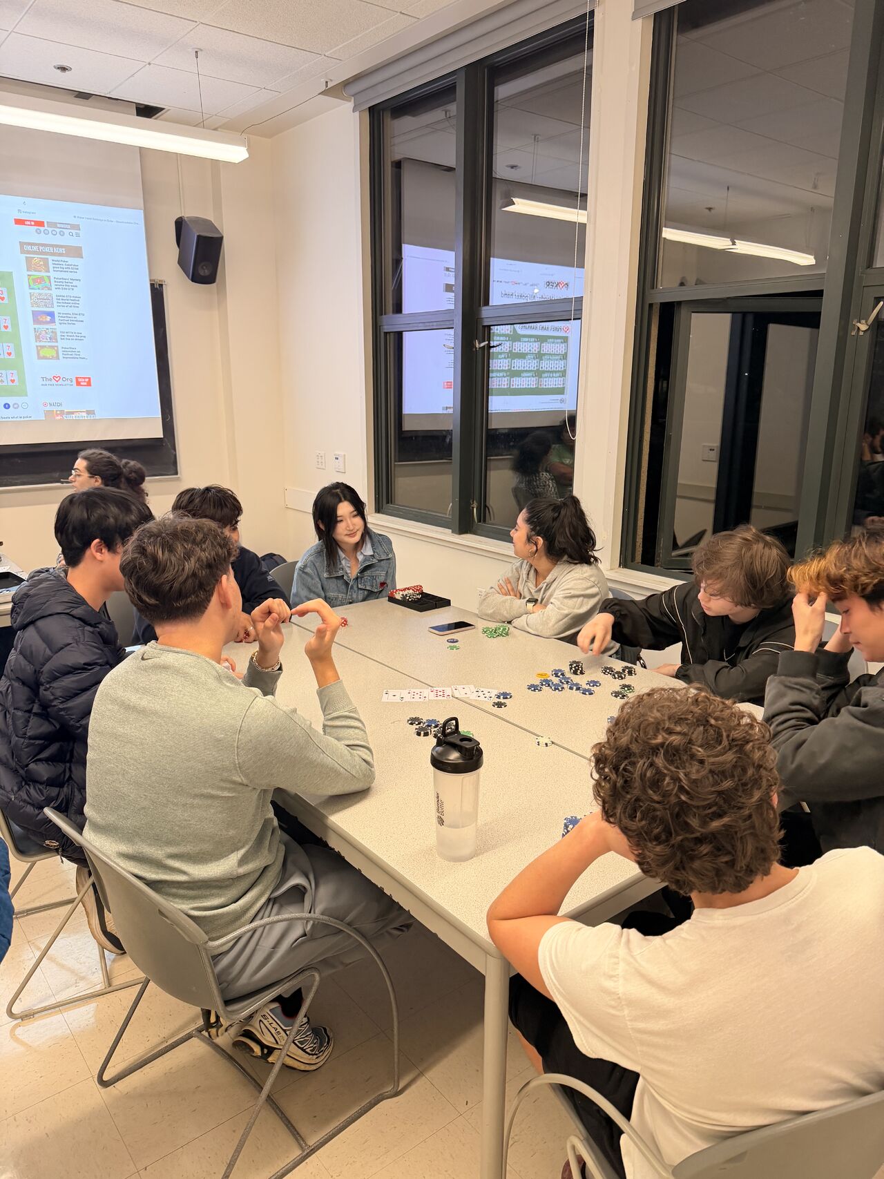 Members around a table with cards and chips at SFIG's first Poker Night